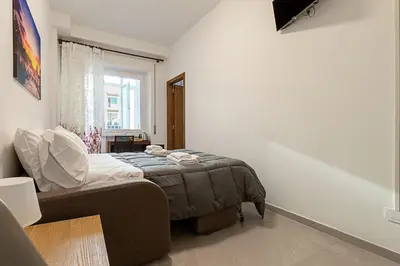 a small bedroom with a bed and a window at Vatican Cipro Guest House in Rome