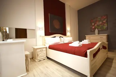 a bedroom with a bed with a red bedspread at Ottaviano 2BR Holiday House in Rome