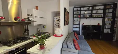 a kitchen with a stove and a couch in a room at L'Oasi di Monteverde - grazioso e collegatissimo in Rome