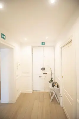 a white hallway with a table and a chair at Saint Peter Beautiful 2BR Apartment in Rome