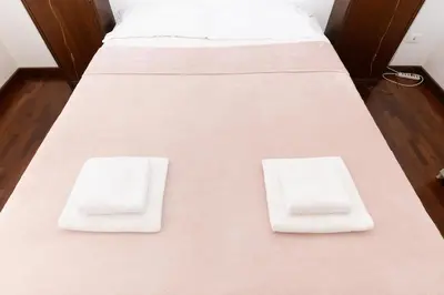 two beds with white sheets and white towels on them at 10 Min Città del Vaticano-Stadio olimpico Lucia Apartment 1BDR in Rome