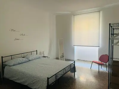 a bedroom with a bed and a chair and a window at Antoni House San Giovanni in Rome