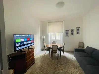 a living room with a table and a flat screen tv at Antoni House San Giovanni in Rome