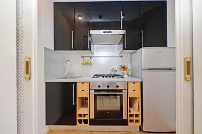 a small kitchen with a sink and a refrigerator at Balcony al Colosseo by Luxury Getaways in Rome