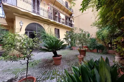 a courtyard with potted plants in front of a building at Balcony al Colosseo by Luxury Getaways in Rome