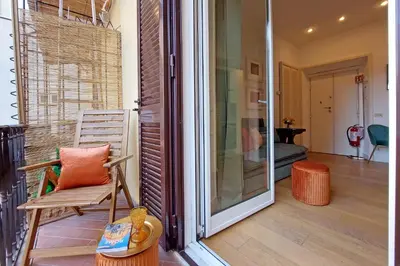 a porch with a chair and a sliding glass door at Balcony al Colosseo by Luxury Getaways in Rome