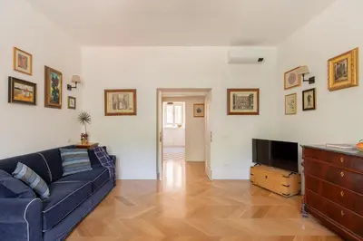 a living room with a blue couch and a tv at iFlat Charming & Spacious Flat in Trastevere in Rome