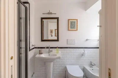 a bathroom with a sink and a toilet and a mirror at iFlat Charming & Spacious Flat in Trastevere in Rome
