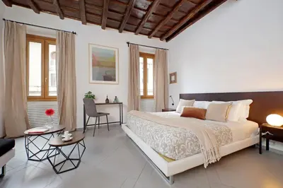 a bedroom with a large bed and a living room at Trastevere Historic Loft by Luxury Getaways in Rome