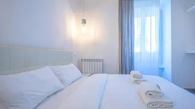 a bedroom with a white bed with towels on it at EasyTopStay - Stylish Vatican Retreat in Rome