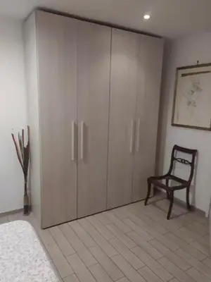 a bedroom with a closet with a chair and a cabinet at Garbatella seminterrato in Rome