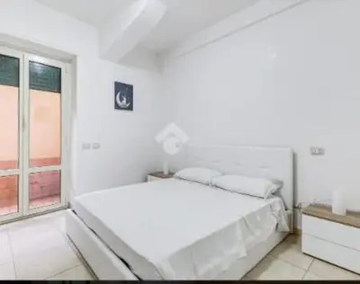 a white bedroom with a bed and a window at Casa Vulture in Rome