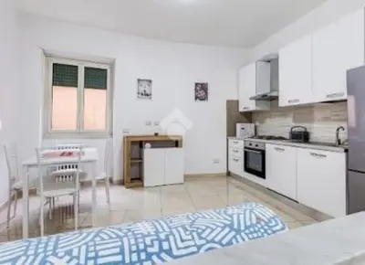a white kitchen with a table and a dining room at Casa Vulture in Rome