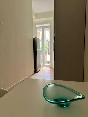 a glass bowl on a counter in a room with a refrigerator at Zaffiro Esquilino charming apartment in Rome