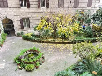 a garden with flowers and plants in front of a building at Residenza Abat-Jour de Rome in Rome