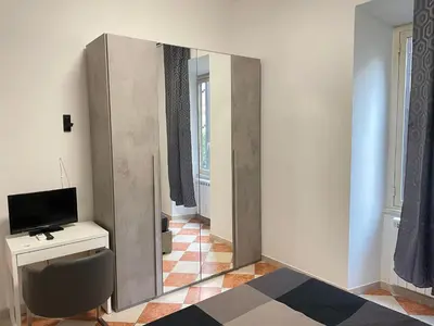 a mirror in a room with a desk and a television at Residenza Abat-Jour de Rome in Rome
