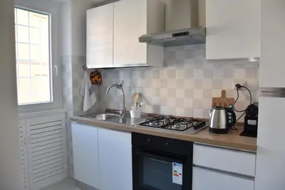 a kitchen with white cabinets and a stove top oven at Metro Battistini- D'Alessandro Holiday Home in Rome