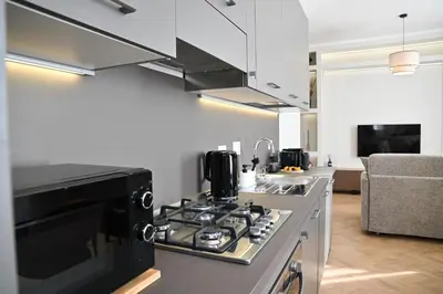a kitchen with a stove top oven next to a couch at Appia Luxury Apartment in Rome