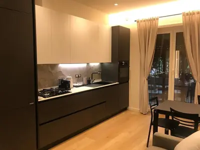 a kitchen with black cabinets and a table and a dining room at Domus de Core in Rome
