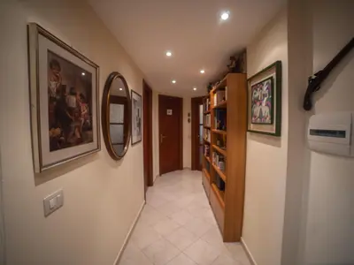 a hallway with paintings on the walls and a mirror at casa di Nadia in Rome