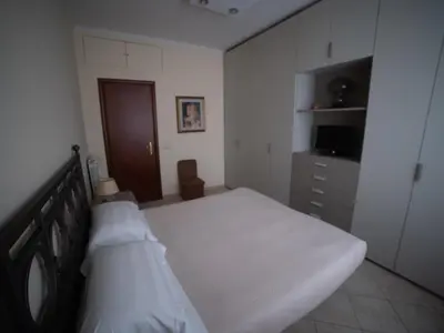 a bedroom with a white bed and a dresser at casa di Nadia in Rome