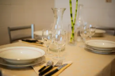 a table with plates and wine glasses on it at casa di Nadia in Rome