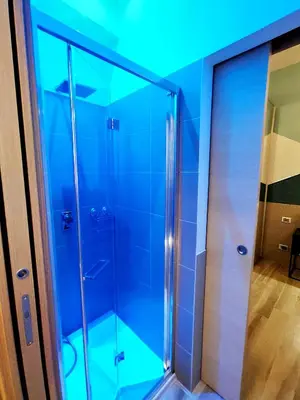 a glass shower in a bathroom with a blue ceiling at Appartamento in Via dei 3 Pupazzi 12 in Rome