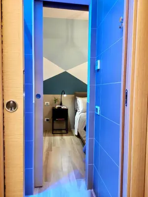 a hallway with blue walls and a bed in a room at Appartamento in Via dei 3 Pupazzi 12 in Rome