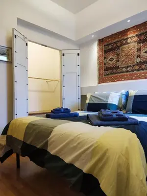 two beds in a bedroom with blue blankets on them at Di casa al Colosseo in Rome