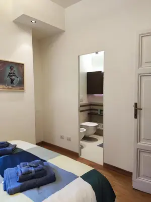 a bedroom with a bed and a bathroom at Di casa al Colosseo in Rome
