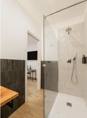 a bathroom with a shower with a glass door at Ventuno Dei Luxury Suites San Giovanni in Rome