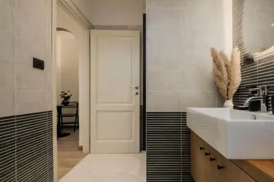 a bathroom with a sink and a white door at Trastevere Luxury Studio in Rome