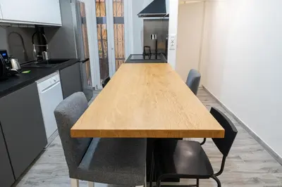 a long wooden table in a kitchen with chairs at Luxury suite al Vaticano in Rome