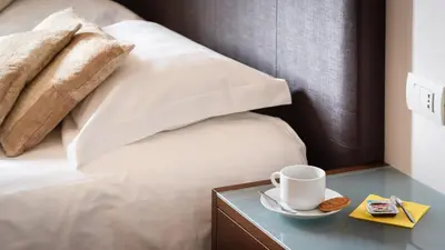 a bed with a cup of coffee on a table at A Trastevere da M.E. in Rome