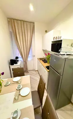 a small kitchen with a table and a refrigerator at SUITE56Roma in Rome