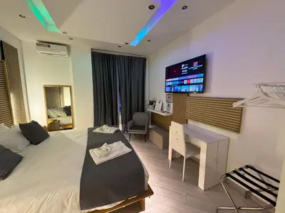 a bedroom with a bed and a desk and a tv at SUITE56Roma in Rome