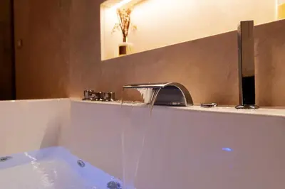 a bath tub with a faucet in a bathroom at HeySuite Classic - Luxury House - Navona in Rome