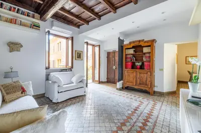 a living room with a white couch and a chair at NOSTROMONDO Prestigious 2 bedrooms Domus in Forum Area in Rome
