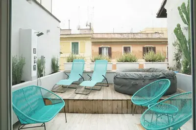 a patio with chairs and a bag on a balcony at Vatican Luxury Duplex in Rome