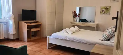 a small bedroom with a bed and a television at Auror house in Rome