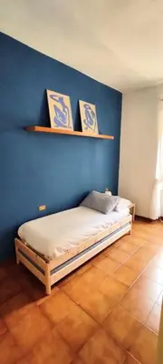 a bedroom with a bed against a blue wall at Auror house in Rome