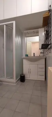 a kitchen with white cabinets and a tile floor at Auror house in Rome
