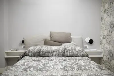 a bedroom with a bed and a white wall at Roma Vaticano Deluxe Apartment in Rome