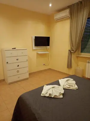 a bedroom with a bed and a dresser and a television at Gemelli House in Rome