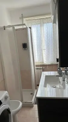 a white bathroom with a shower and a sink at Gemelli House in Rome