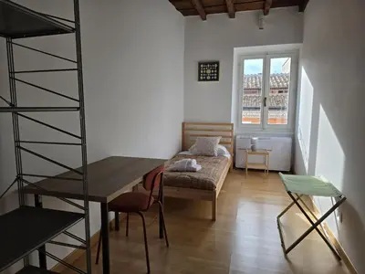 a room with a table and a couch and a chair at Be Your Home - CasAngelica in Rome