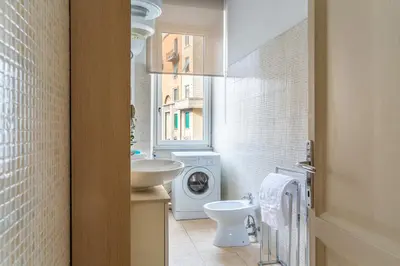 a bathroom with a sink and a washing machine at iFlat Vatican Bright & Comfortable Apartment in Rome