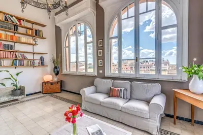 a living room with a couch and large windows at Napoleone 2 bedroom apartment in Rome