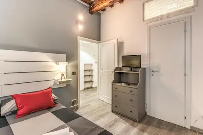 a bedroom with a bed and a dresser with a television at Monti Studio Roman Forum in Rome