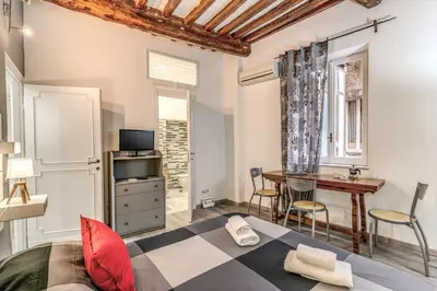 a bedroom with a bed and a desk and a table at Monti Studio Roman Forum in Rome
